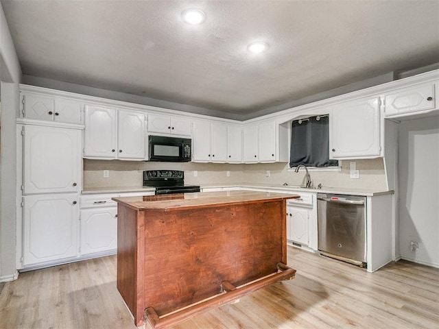 kitchen with a kitchen island, white cabinets, black appliances, and light hardwood / wood-style flooring