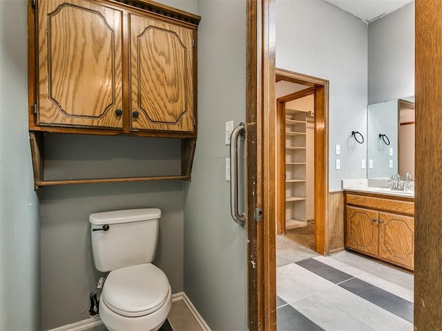 bathroom with toilet, vanity, and tile patterned floors