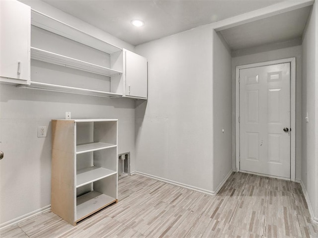 laundry room with cabinets and light hardwood / wood-style flooring