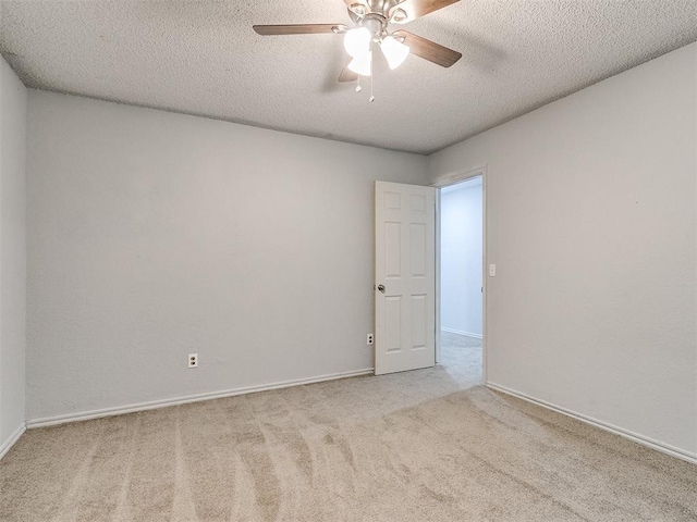 spare room featuring a textured ceiling, ceiling fan, and light colored carpet