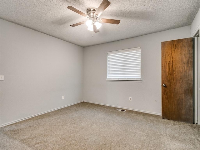 carpeted spare room featuring a textured ceiling and ceiling fan