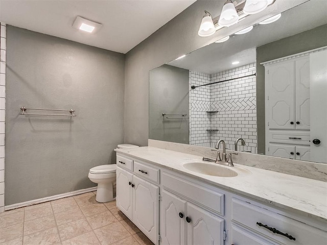 bathroom featuring tiled shower, tile patterned floors, vanity, and toilet