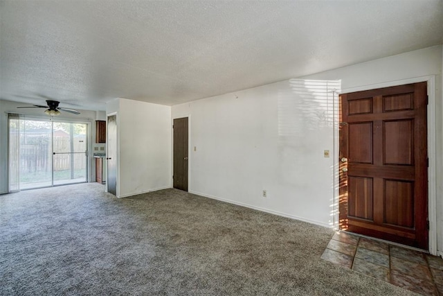 unfurnished living room featuring a textured ceiling, dark carpet, and ceiling fan