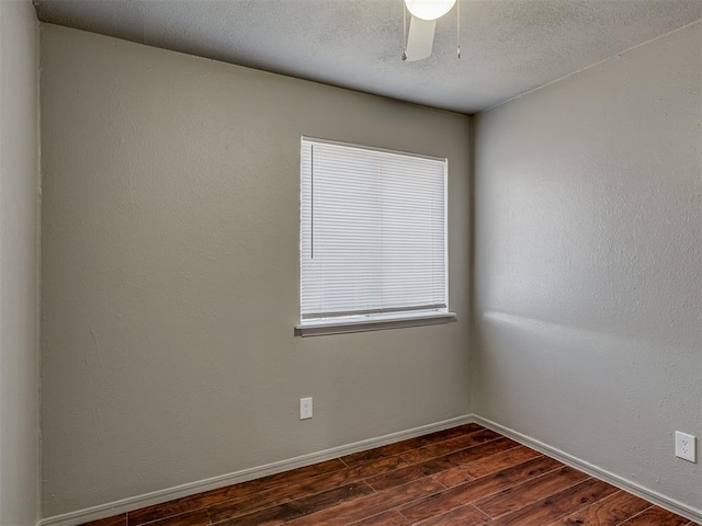 spare room with dark hardwood / wood-style floors, ceiling fan, and a textured ceiling