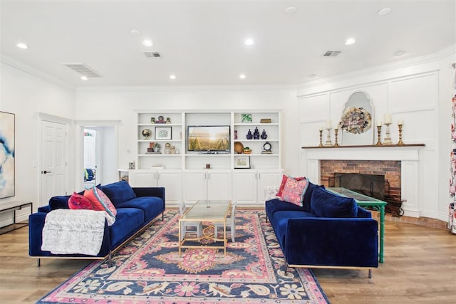 living room featuring a brick fireplace, hardwood / wood-style flooring, built in features, and ornamental molding