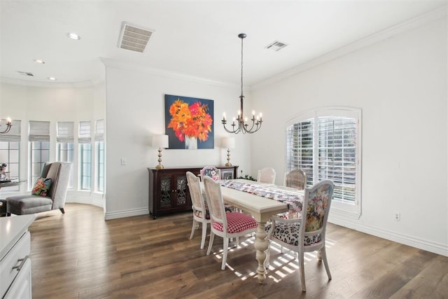 dining room with crown molding, dark wood-type flooring, and a chandelier