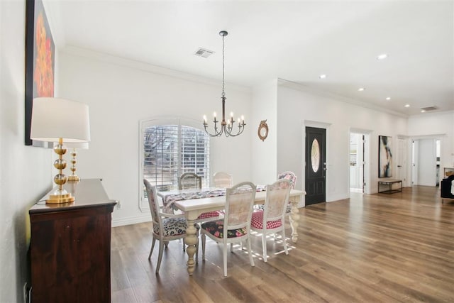 dining room featuring a notable chandelier, crown molding, and dark hardwood / wood-style floors