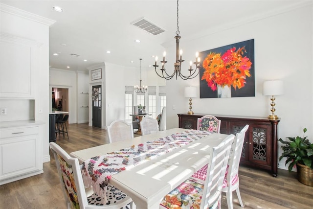 dining area featuring crown molding, dark hardwood / wood-style flooring, and an inviting chandelier