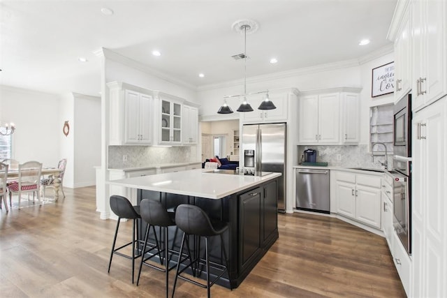 kitchen with stainless steel appliances, a center island, and white cabinets