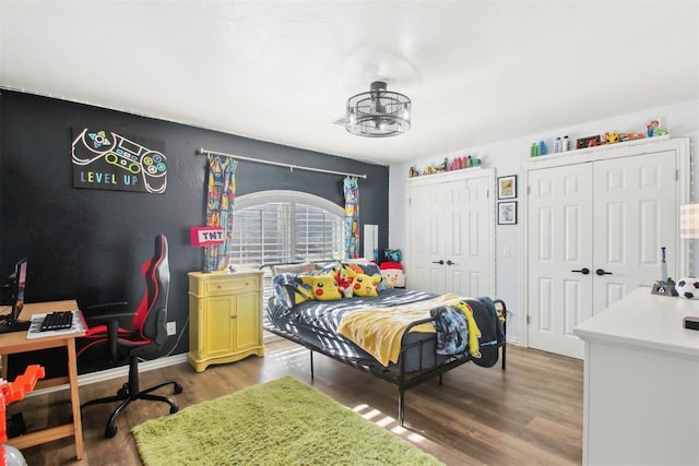 bedroom featuring multiple closets and wood-type flooring