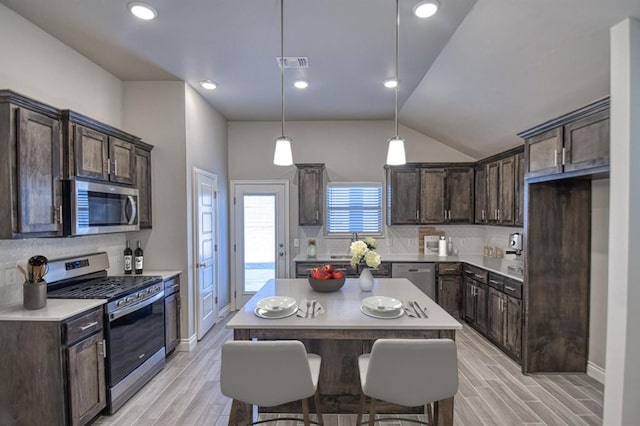 kitchen with backsplash, a kitchen island, and appliances with stainless steel finishes