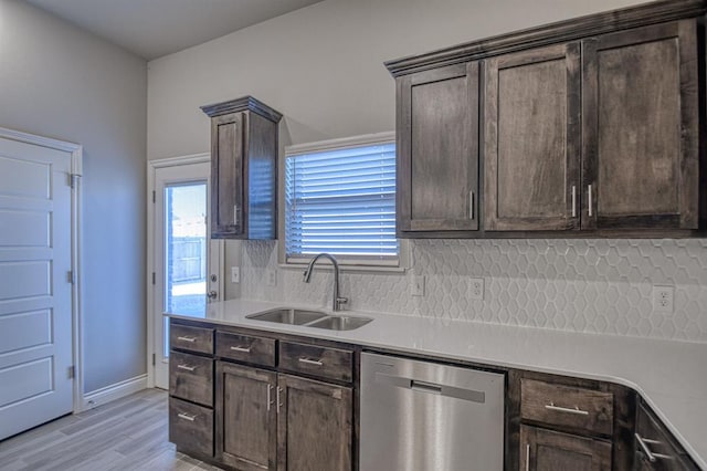 kitchen featuring sink, stainless steel dishwasher, decorative backsplash, dark brown cabinets, and light wood-type flooring