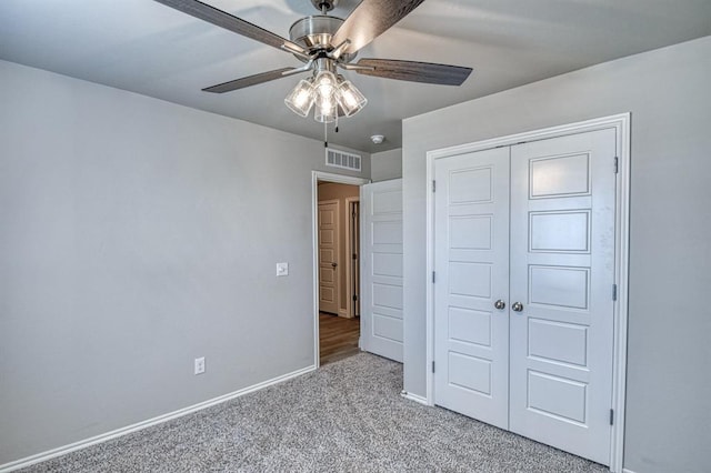 unfurnished bedroom featuring a closet, light colored carpet, and ceiling fan