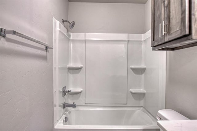 bathroom with shower / bathing tub combination and toilet