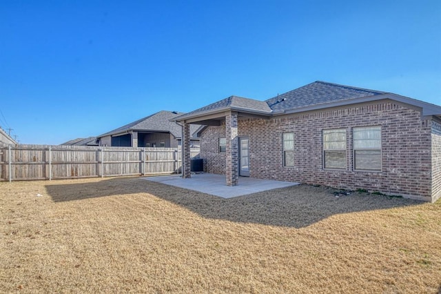 back of house with a lawn and a patio area