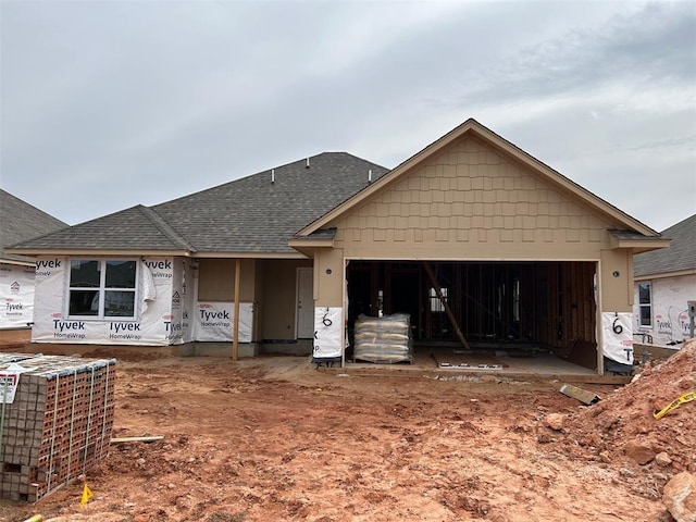 property in mid-construction with a garage, central AC unit, and roof with shingles