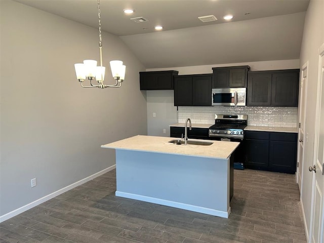 kitchen featuring vaulted ceiling, sink, a center island with sink, and appliances with stainless steel finishes