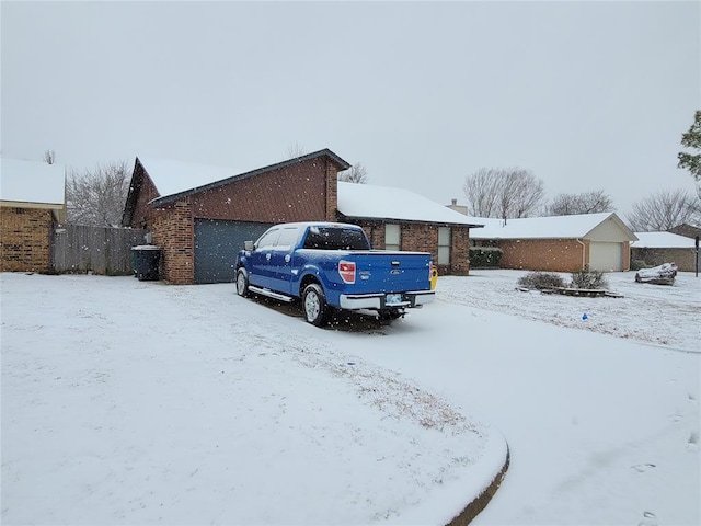 snow covered property with a garage