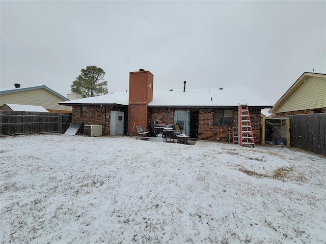 snow covered property with central air condition unit