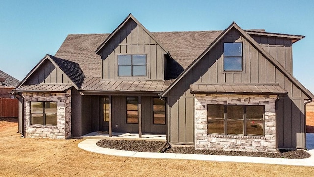 modern inspired farmhouse with roof with shingles, board and batten siding, a standing seam roof, metal roof, and stone siding