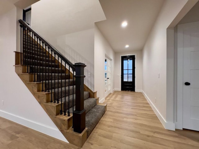 entrance foyer with recessed lighting, stairway, baseboards, and wood finished floors