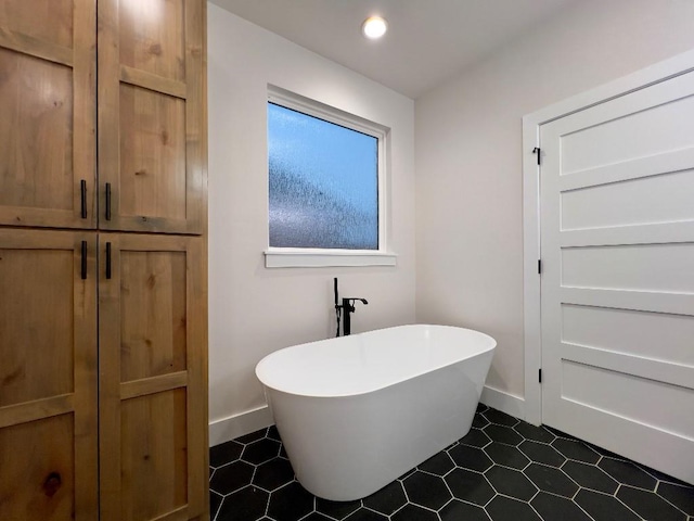 full bathroom with recessed lighting, a freestanding bath, baseboards, and tile patterned floors