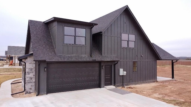 view of front of home featuring a barn, a garage, board and batten siding, and roof with shingles