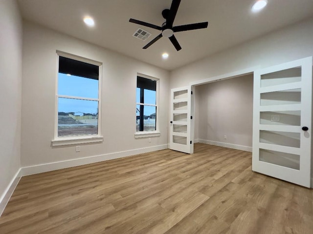 unfurnished bedroom with baseboards, wood finished floors, visible vents, and recessed lighting