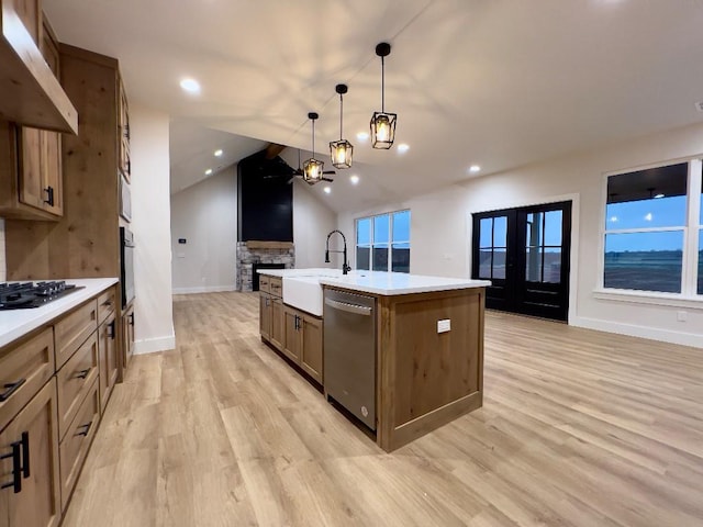 kitchen featuring under cabinet range hood, a sink, gas stovetop, open floor plan, and stainless steel dishwasher