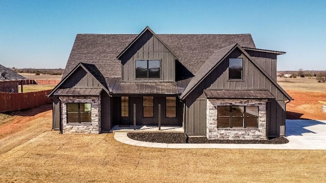 modern farmhouse with board and batten siding, a standing seam roof, and stone siding