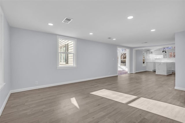 unfurnished living room featuring a healthy amount of sunlight and wood-type flooring