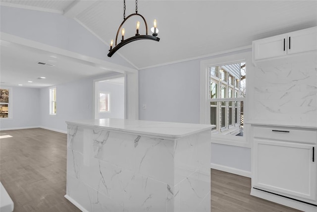 interior space featuring hardwood / wood-style floors, lofted ceiling with beams, and an inviting chandelier