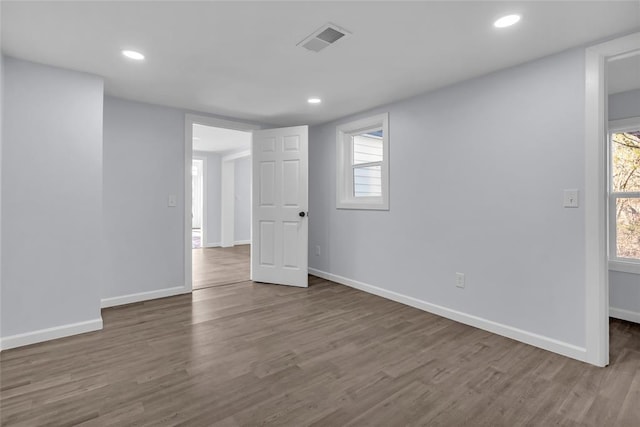 spare room with a healthy amount of sunlight and hardwood / wood-style flooring