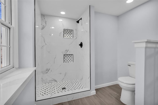 bathroom with hardwood / wood-style flooring, toilet, and walk in shower