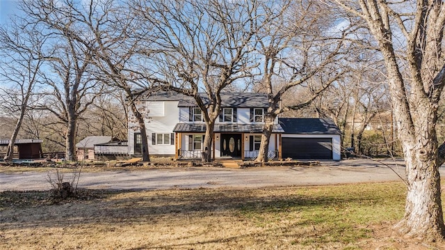 view of front of home featuring a front yard, a porch, and a garage