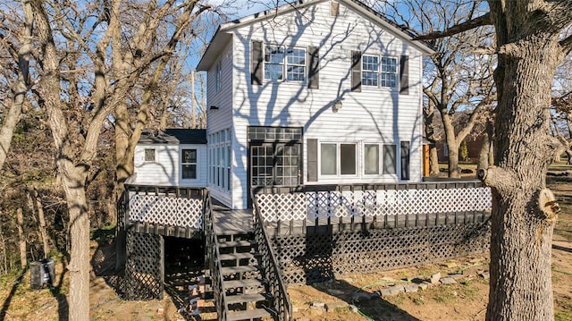 rear view of house with cooling unit and a wooden deck