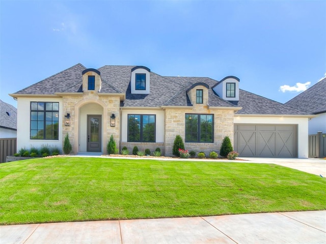2408 Lazio Way, Edmond, OK 73034 - french country home featuring stone siding, concrete driveway, a garage, stucco siding, and roof with shingles