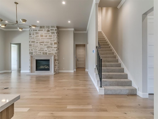 2408 Lazio Way, Edmond, OK 73034 - unfurnished living room with crown molding, stairway, light wood-style floors, a fireplace, and recessed lighting