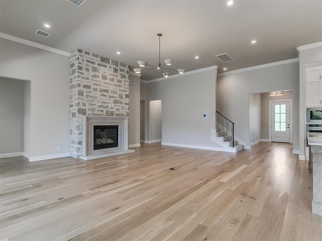 2408 Lazio Way, Edmond, OK 73034 - unfurnished living room featuring ornamental molding, stairs, light wood-style flooring, a stone fireplace, and a chandelier