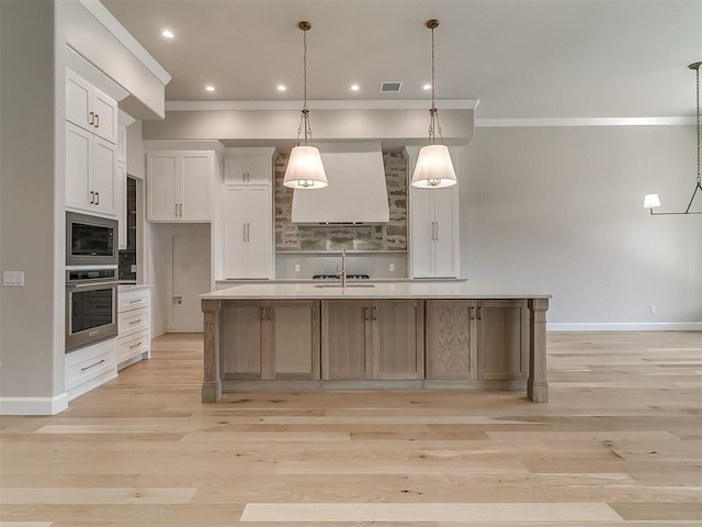 2408 Lazio Way, Edmond, OK 73034 - kitchen featuring stainless steel oven, wall chimney range hood, ornamental molding, white cabinetry, and light wood finished floors