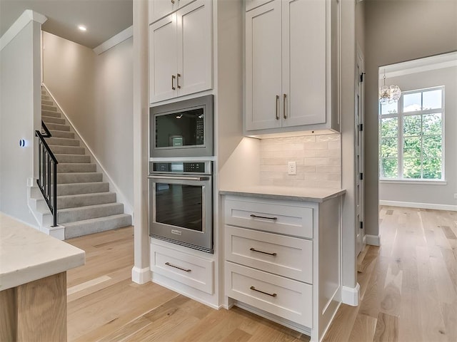 2408 Lazio Way, Edmond, OK 73034 - kitchen with appliances with stainless steel finishes, light wood-style flooring, backsplash, a chandelier, and recessed lighting