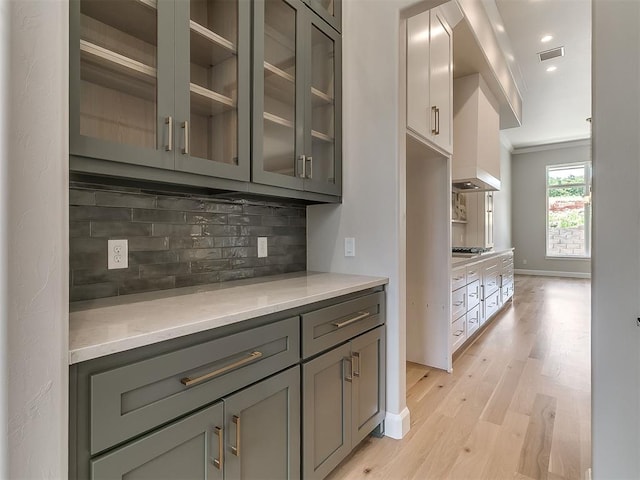 2408 Lazio Way, Edmond, OK 73034 - kitchen with gray cabinets, backsplash, light wood finished floors, glass insert cabinets, and recessed lighting