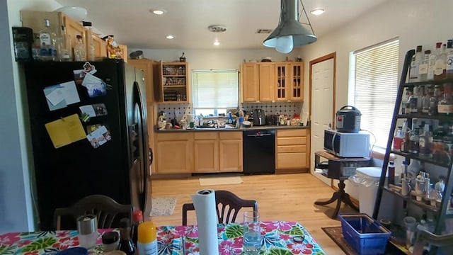 kitchen with light wood finished floors, decorative backsplash, light brown cabinetry, glass insert cabinets, and black appliances