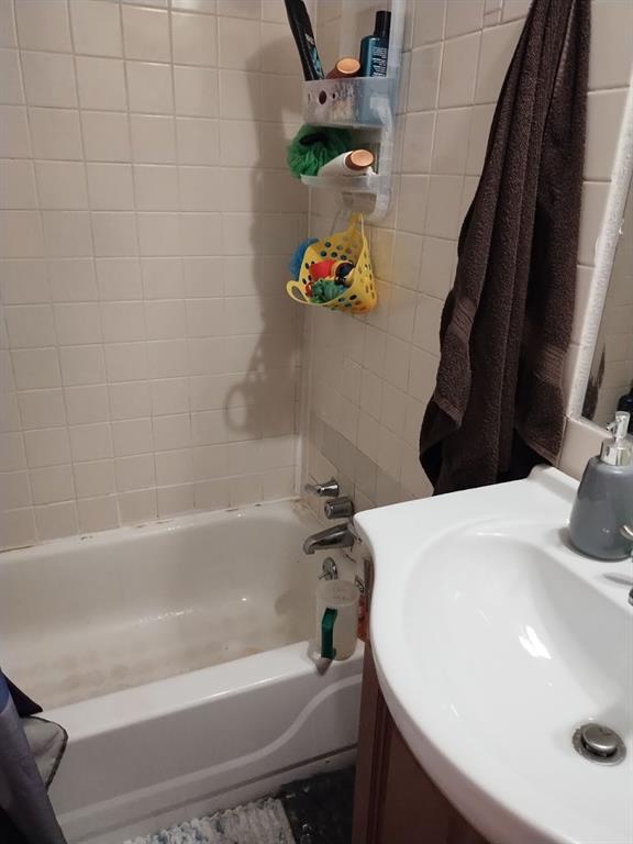 bathroom with shower / tub combo and a sink