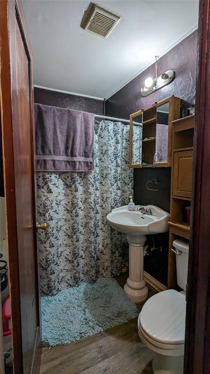 full bathroom with curtained shower, visible vents, toilet, and wood finished floors