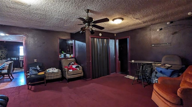 interior space with a ceiling fan, a textured wall, and a textured ceiling