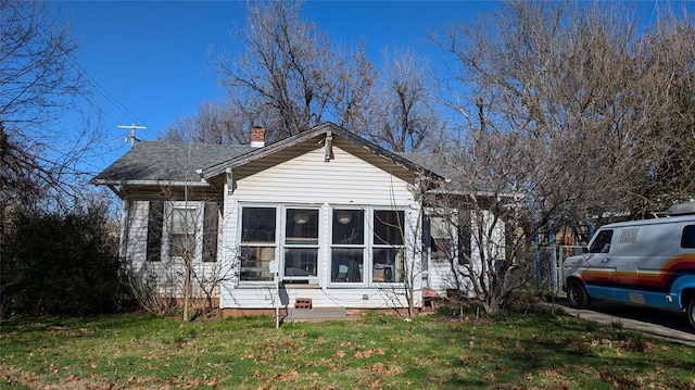 view of side of property featuring a yard and a chimney