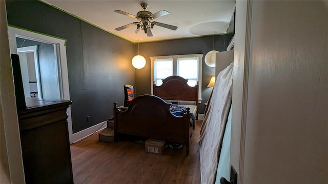 bedroom featuring ceiling fan, wood finished floors, and baseboards