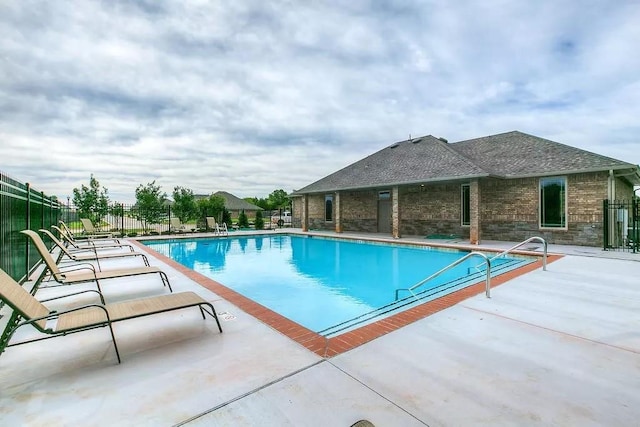 pool with a patio and fence