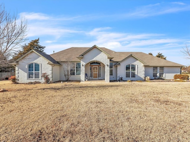 single story home with covered porch and a front lawn